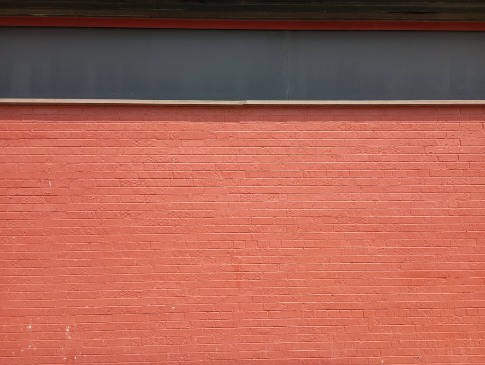 una pared de ladrillo rojo con una señal de alto