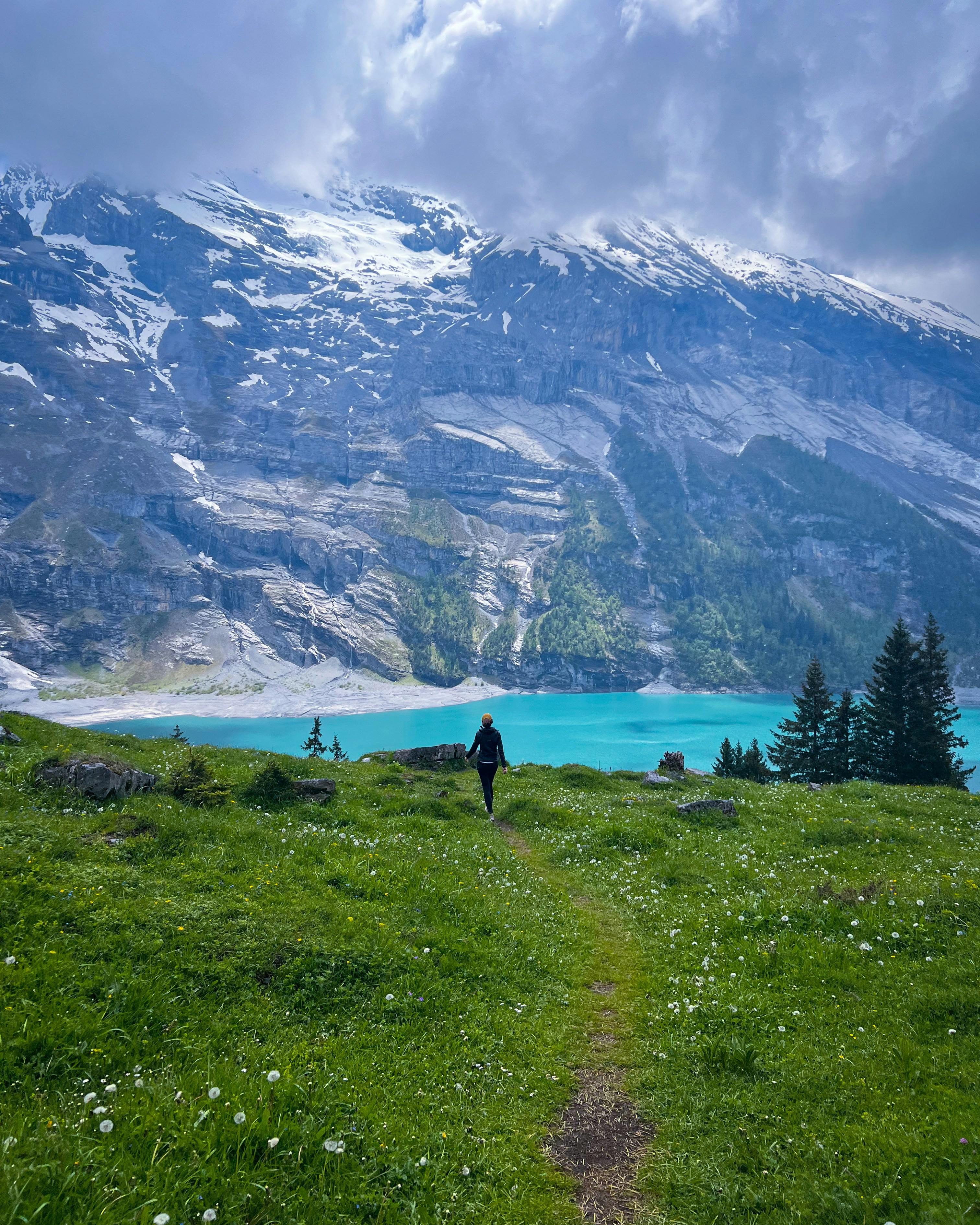 a person walking up a grassy hill towards a lake