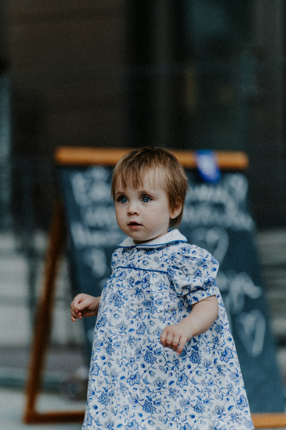 a little girl in a blue and white dress