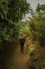 A traveler walking along the ancient Camino de Santiago trail surrounded by lush greenery.