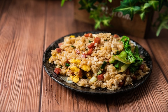 A colorful plate of Chinese fried rice with vegetables and egg, styled for a restaurant menu.