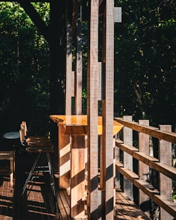 Sunlight filtering through leaves onto traditional tools arranged on a rustic wooden table.