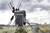 an old wooden windmill in the middle of a field