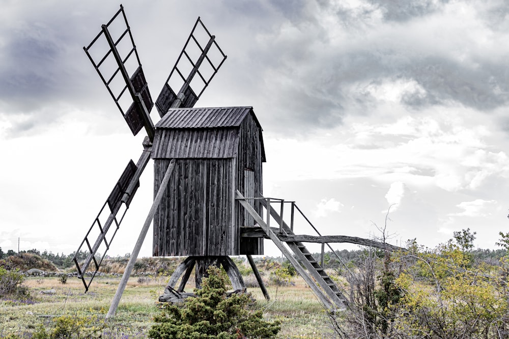 eine alte hölzerne Windmühle mitten auf einem Feld