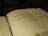 An open book with text in Tagalog, indicating it's a religious script, possibly a Bible. The page shows black printed letters on an aged, yellowish surface.