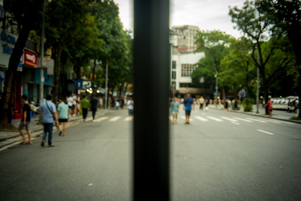 a group of people walking down a street next to tall buildings