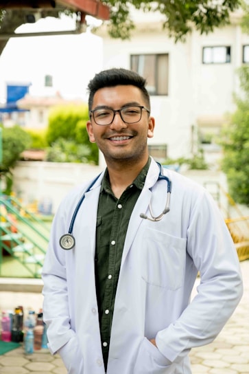 Dr. Jules smiling warmly during a casual outdoor medical outreach event.