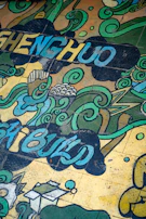 An inspiring mural painted by local youth, featuring blue tones and symbols of education.