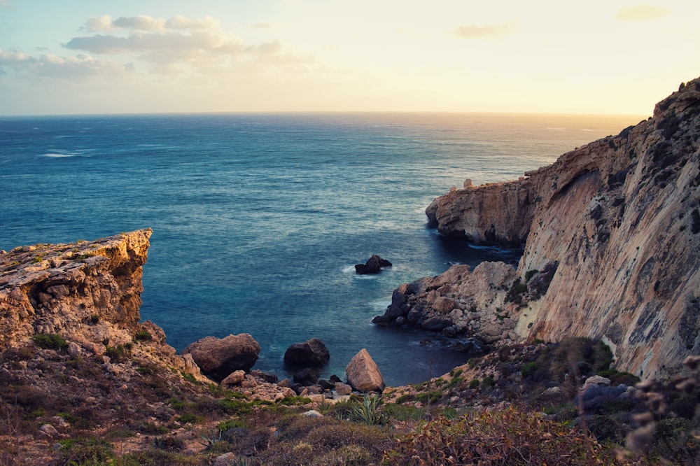 a rocky cliff overlooks a body of water