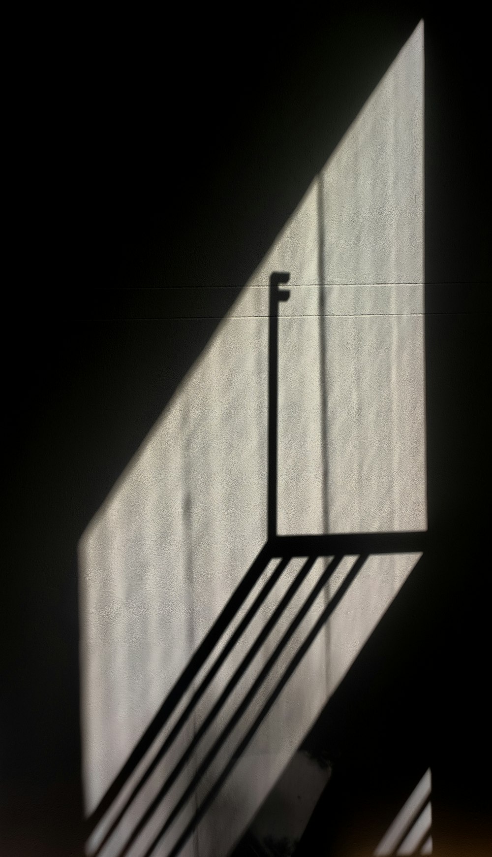 a black and white photo of the shadow of a stair case