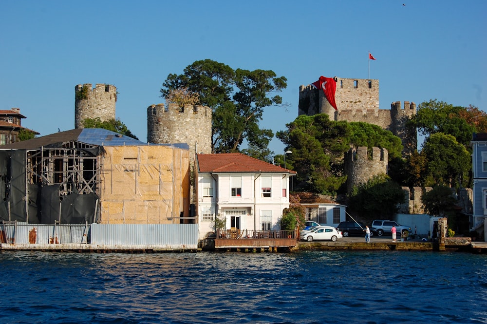 a house on the water with a castle in the background