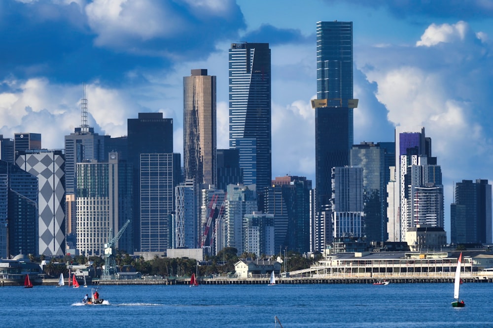 a city skyline with sailboats in the water