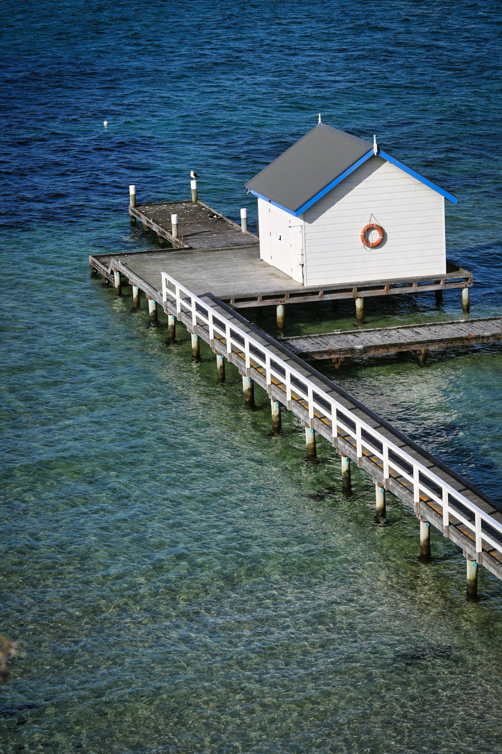 a small white house sitting on top of a pier