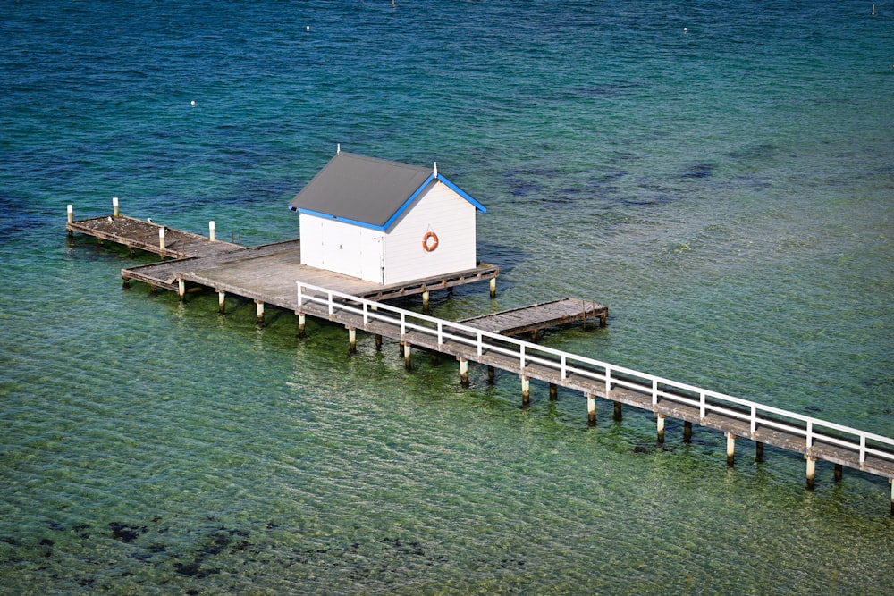 Ein weißes Haus, das auf einem Pier neben dem Meer sitzt