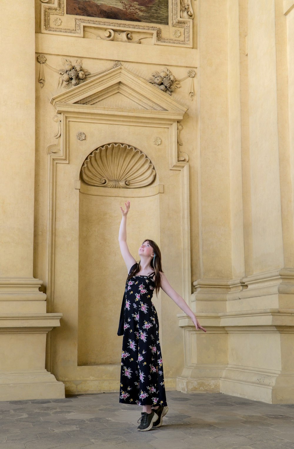 a woman standing in front of a building with her arms in the air