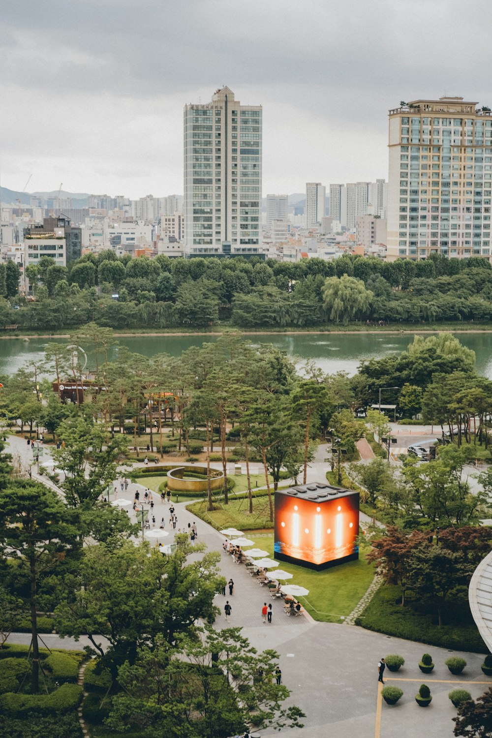 a view of a park with a lot of trees and buildings in the background