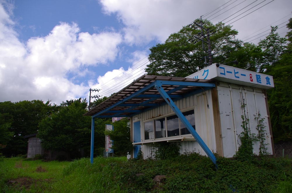 a small building sitting on top of a lush green hillside