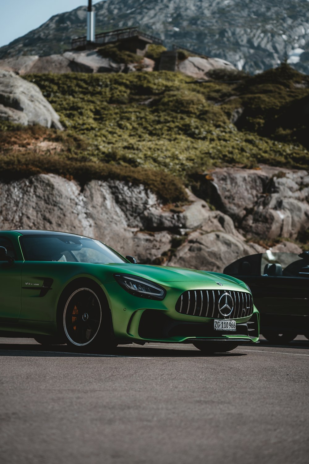 a green sports car parked next to a black sports car