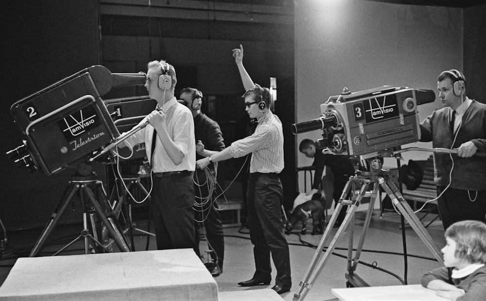 a group of people standing around a camera