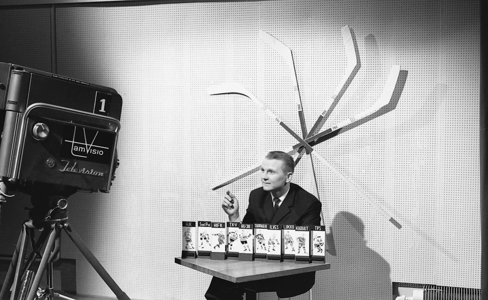 a man in a suit and tie holding a box of cards in front of a