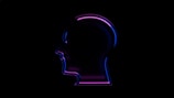 A neon outline of a human head profile in side view against a black background, featuring vivid blue and purple colors that create a glowing effect.