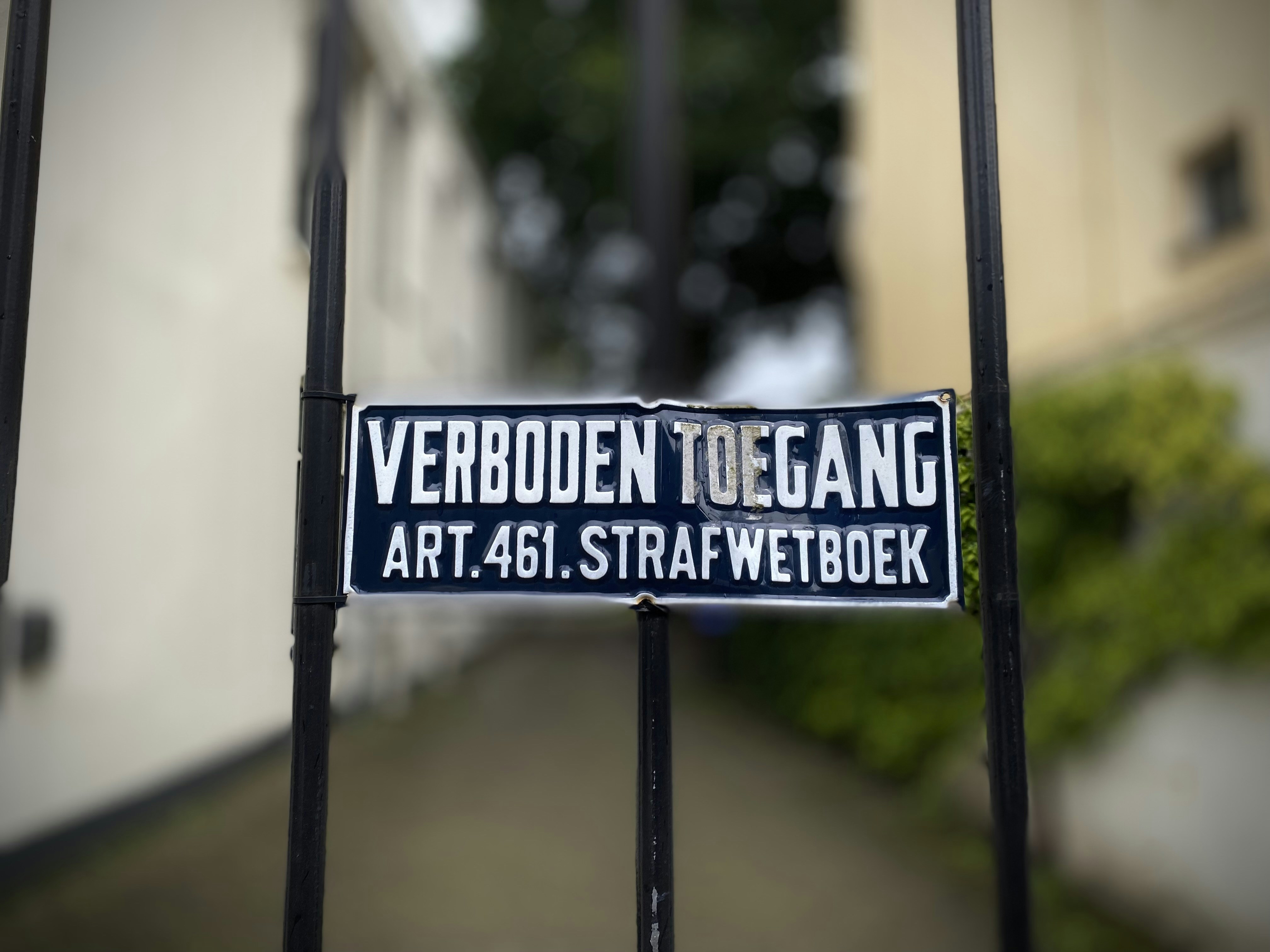 Black and white street sign on a metal fence