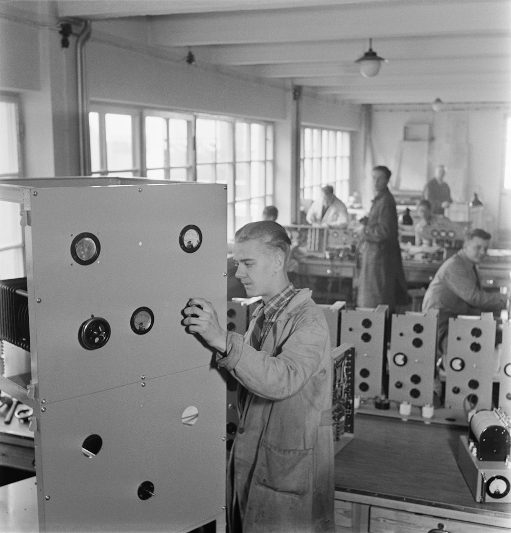 a man standing next to a machine in a factory