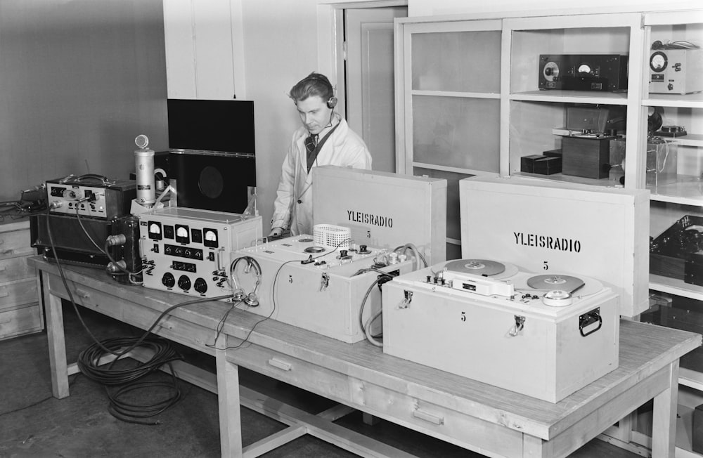 a man standing next to a table filled with electronics