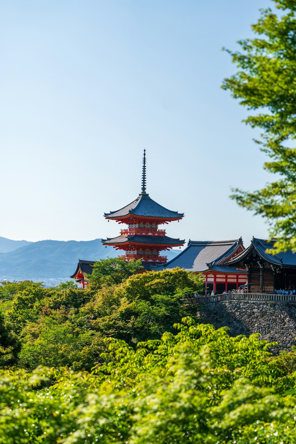 a tall red building sitting on top of a lush green hillside