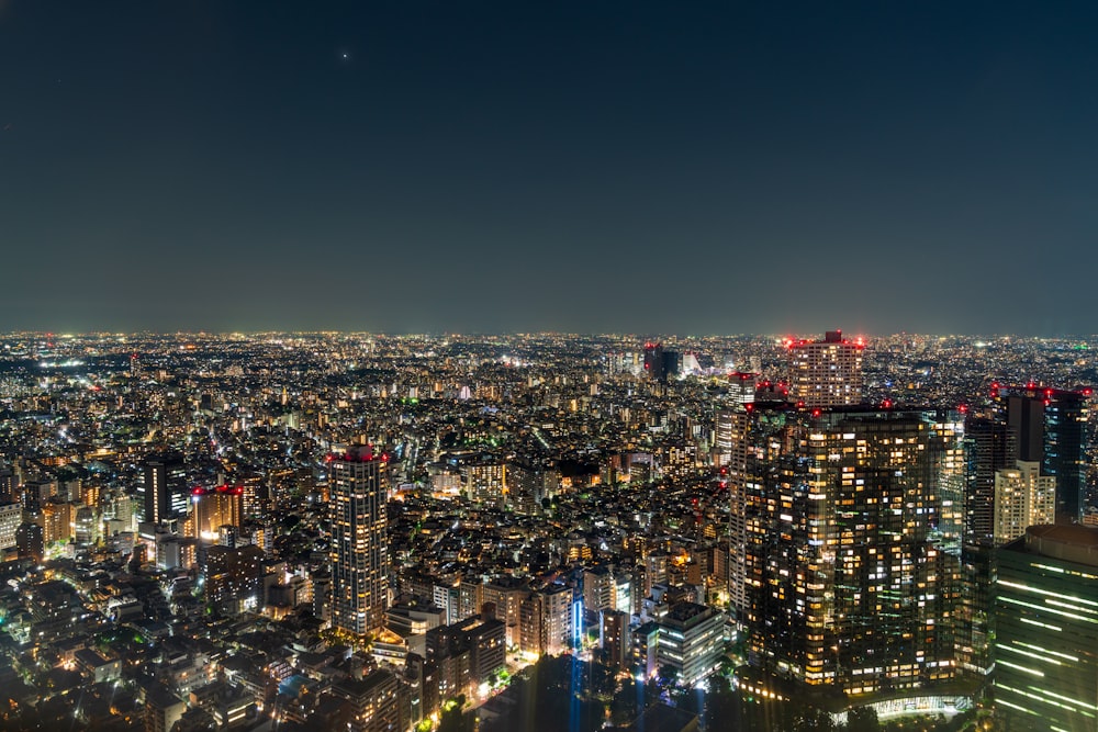 a view of a city at night from the top of a skyscraper