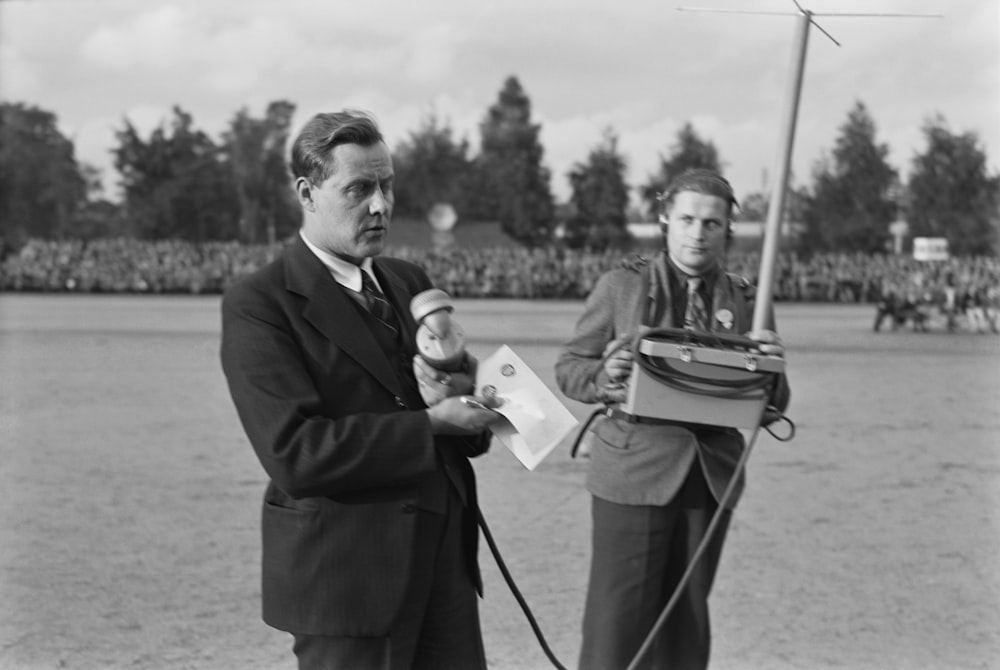 a black and white photo of two men with microphones