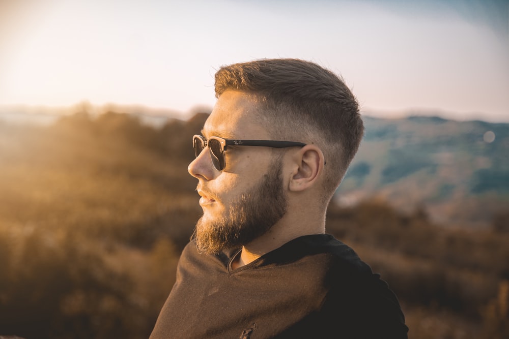 a man with a goatee and sunglasses looking off into the distance