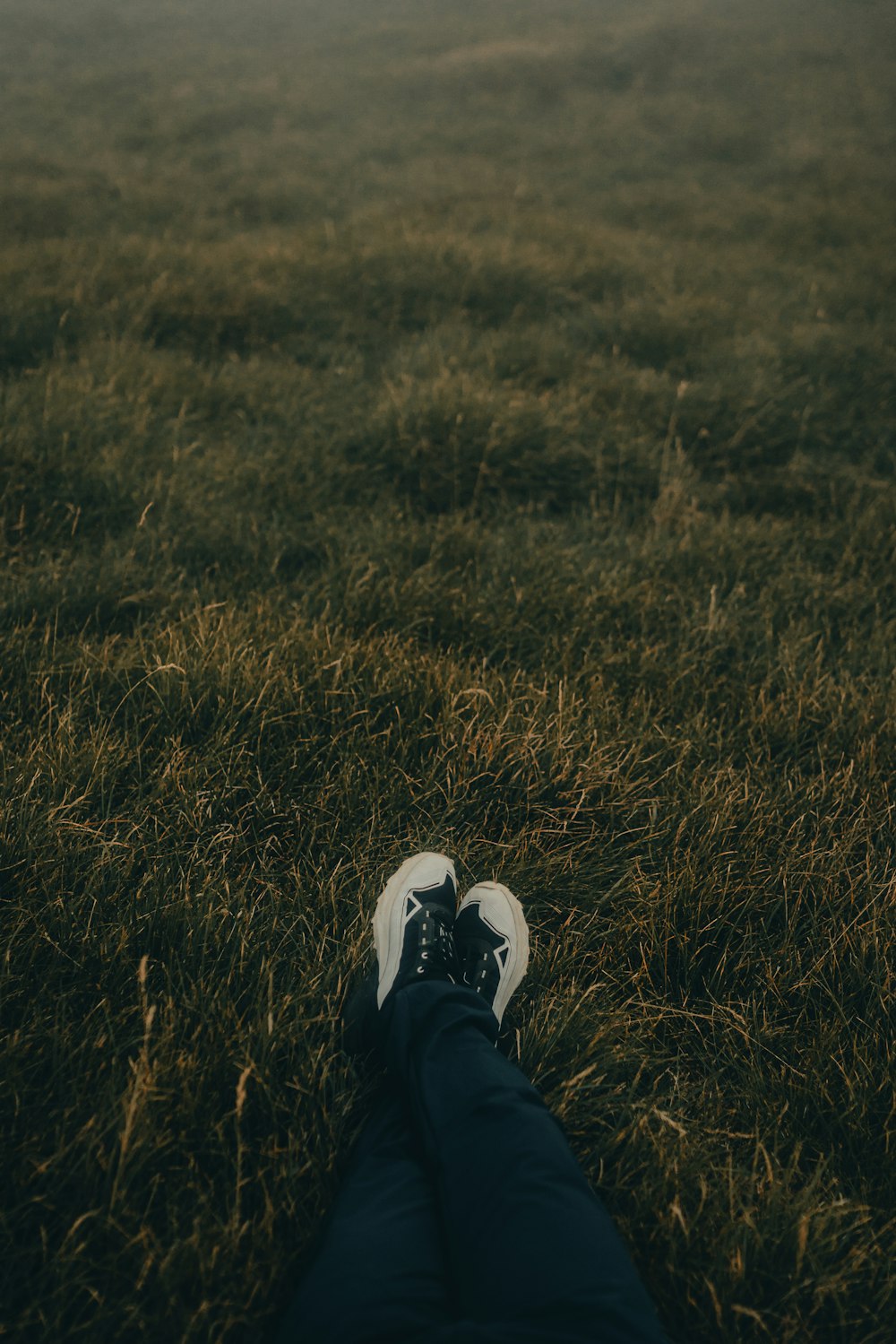 una persona sdraiata sull'erba con i piedi alzati