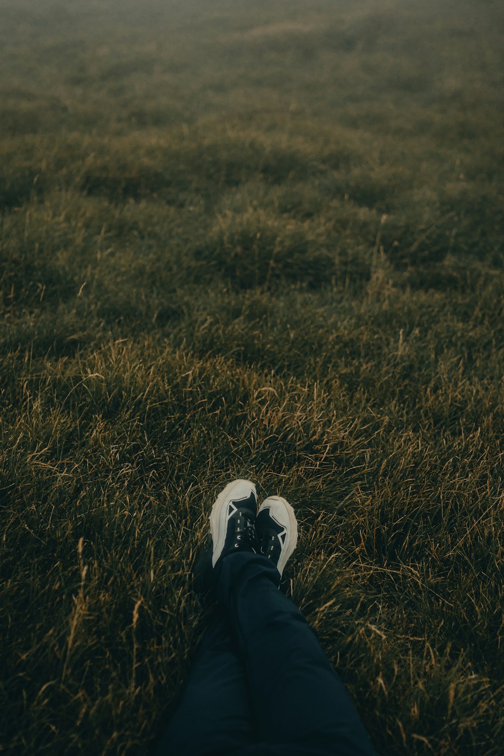 a person laying in the grass with their feet up