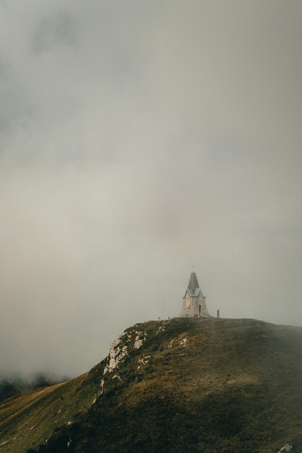 a house on a hill with a cloudy sky