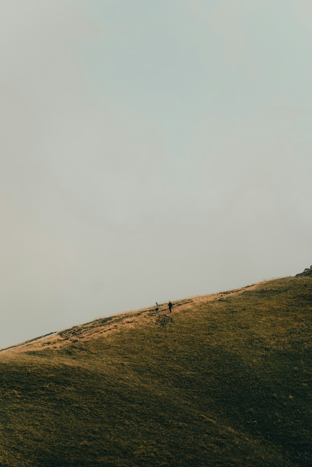 une personne qui monte une colline par temps nuageux