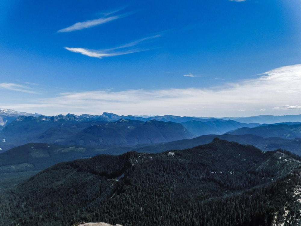 a person standing on top of a mountain with a snowboard