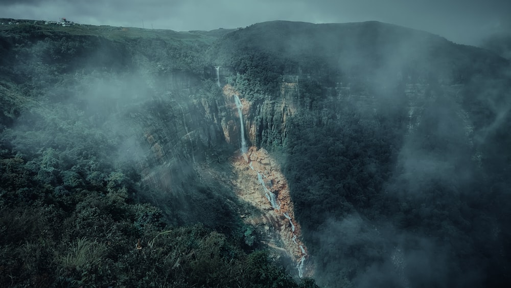 a waterfall in the middle of a lush green forest