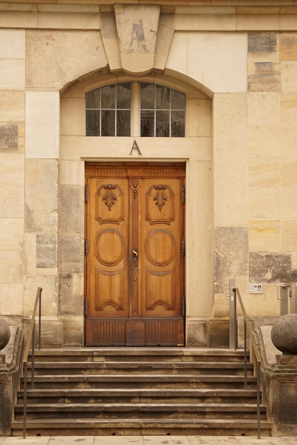 a large wooden door sitting next to a set of steps