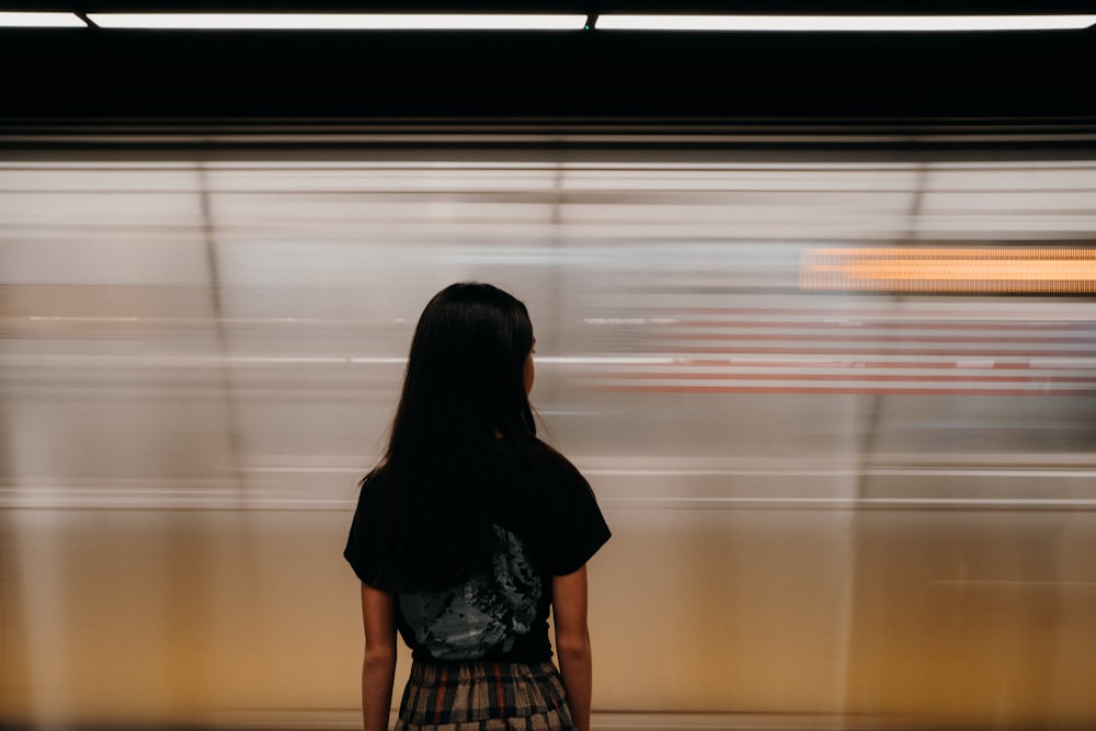 a woman standing in front of a train