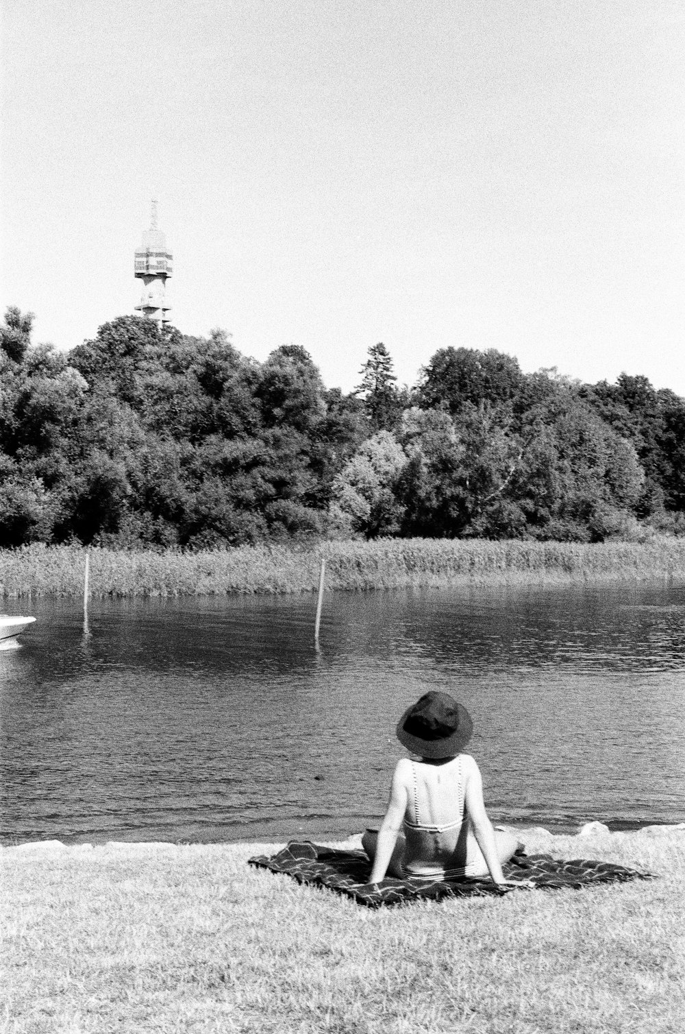 a person sitting on the grass near a body of water