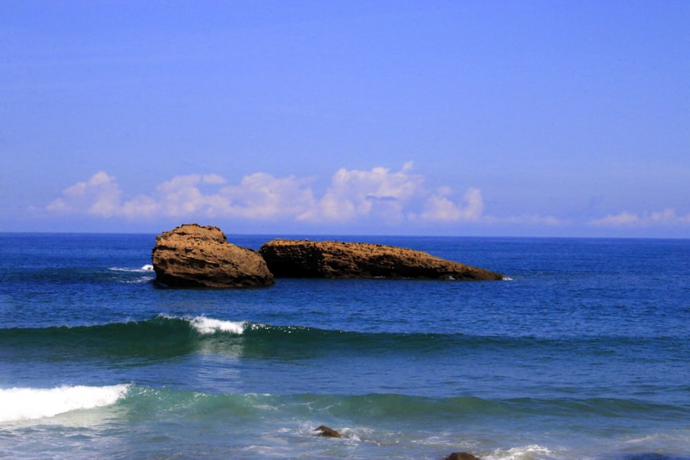 a large rock sticking out of the ocean