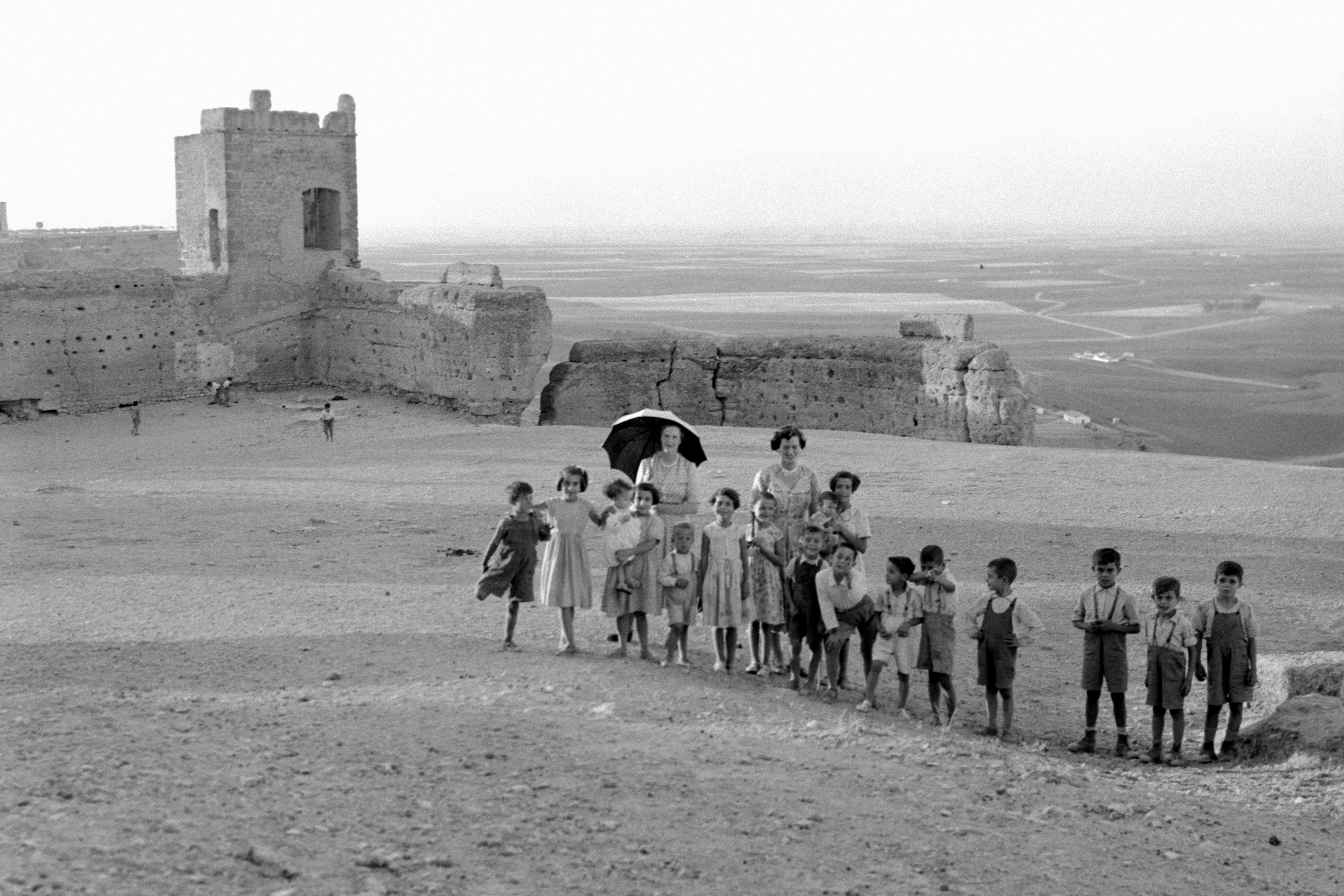 a group of people standing on top of a dirt field