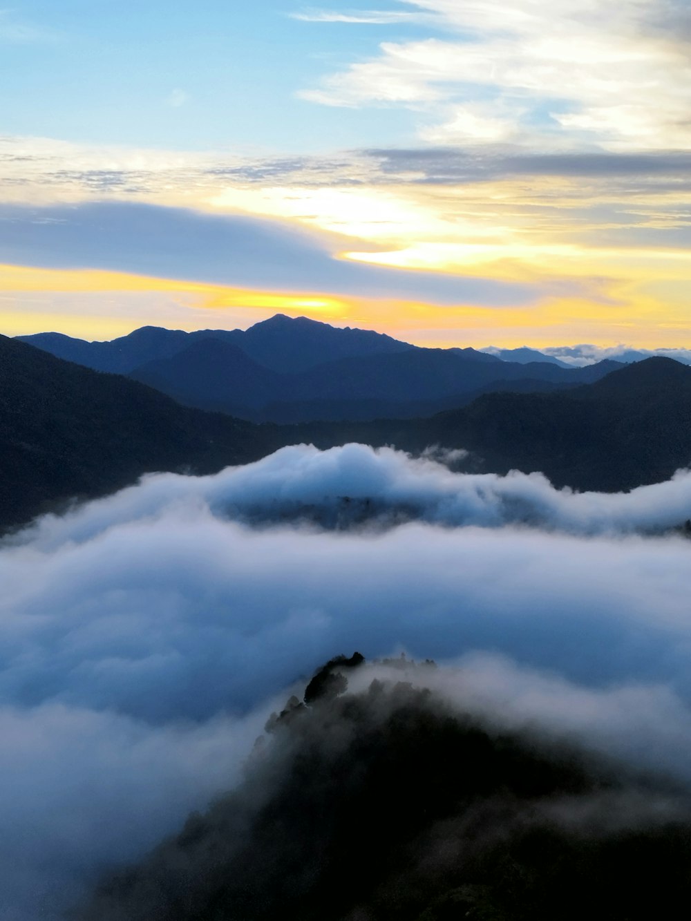 a view of a mountain range covered in clouds