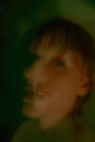 A blurred face with fragmented features, as if seen through a cracked mirror reflecting inner turmoil.