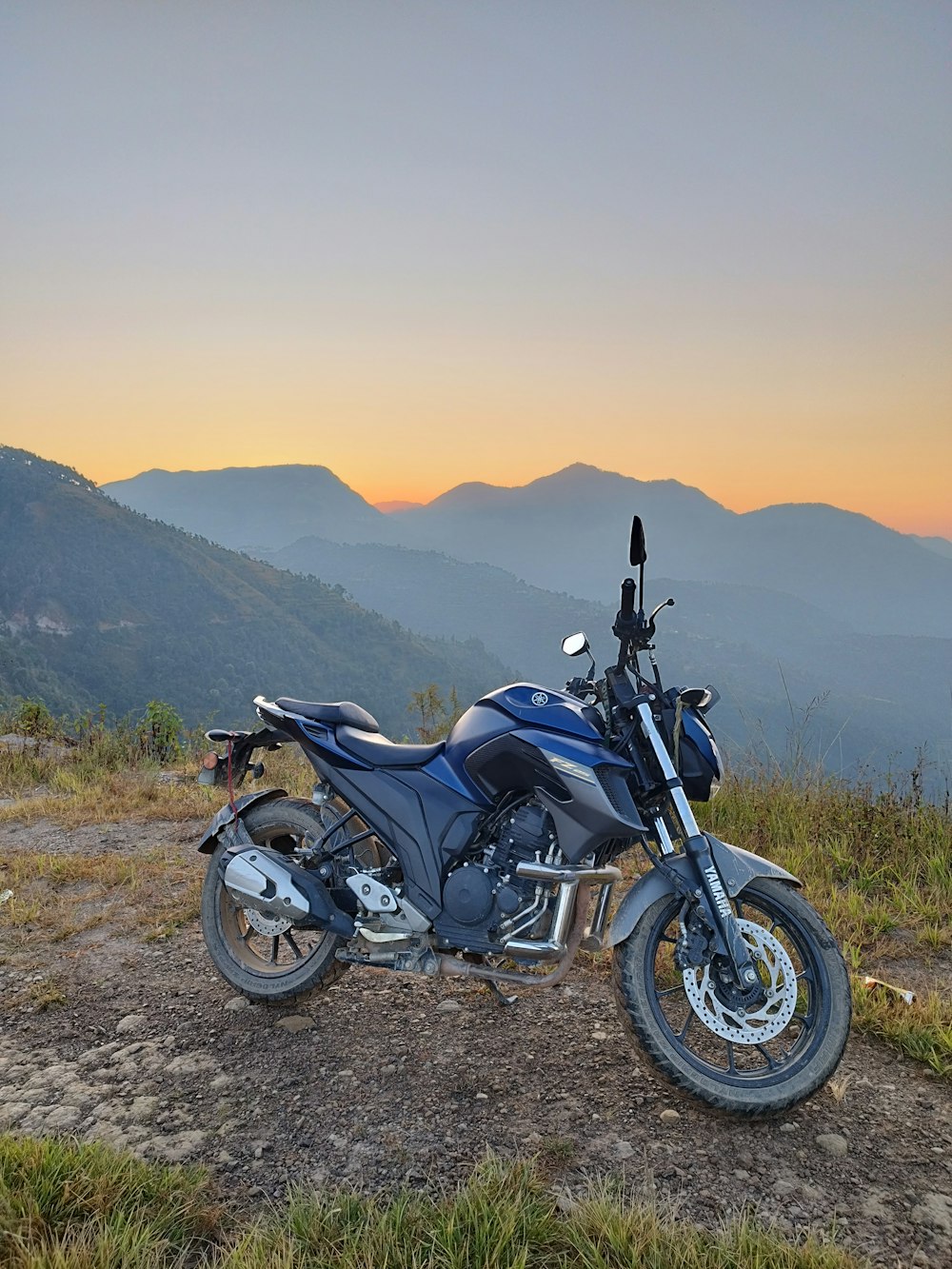 a motorcycle parked on top of a dirt field