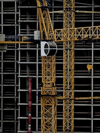 a yellow crane sitting on top of a building under construction