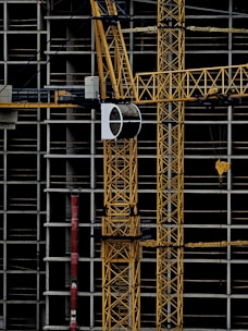 a yellow crane sitting on top of a building under construction