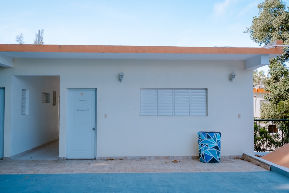 a white house with a blue vase in front of it