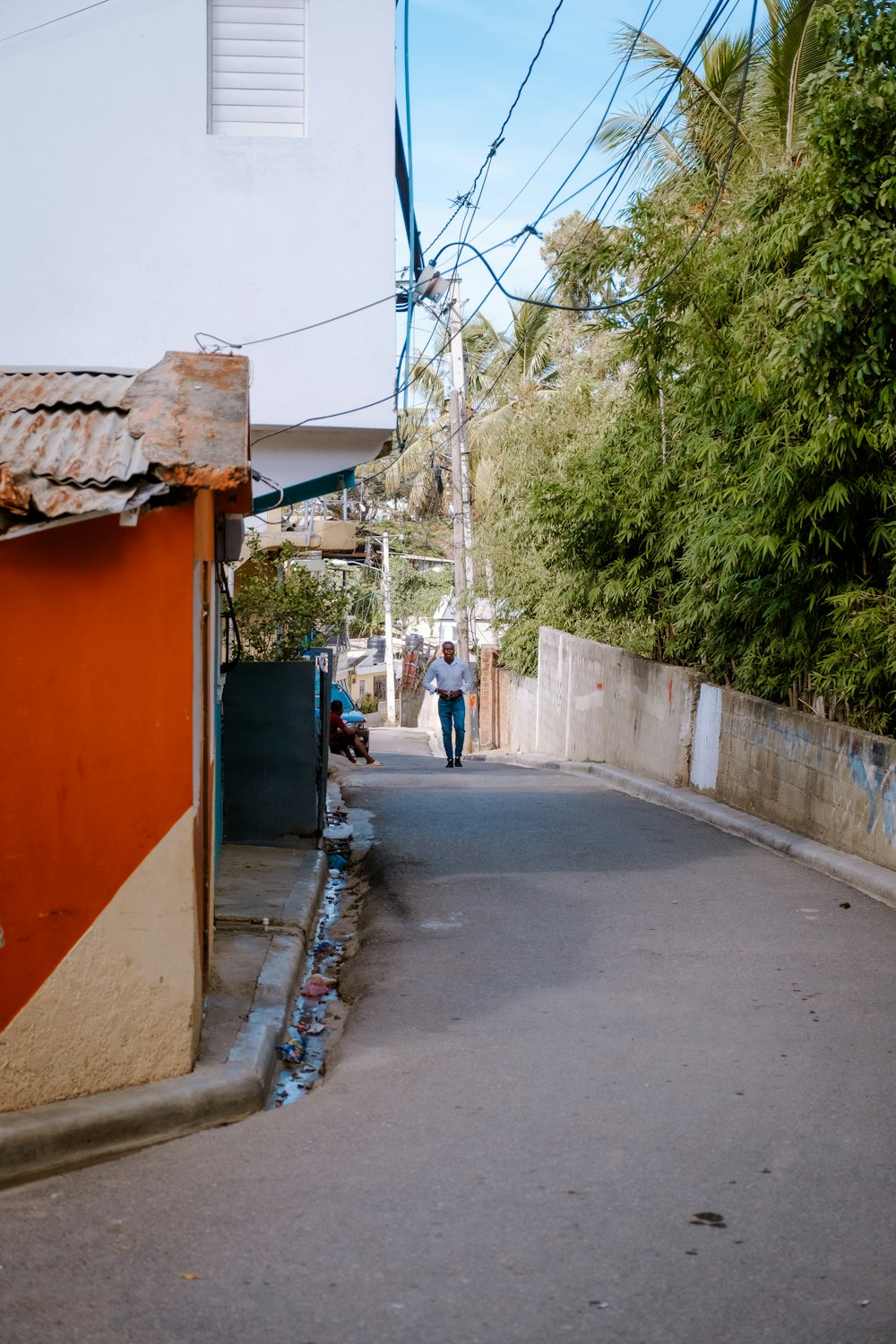 a person walking down a street next to a building